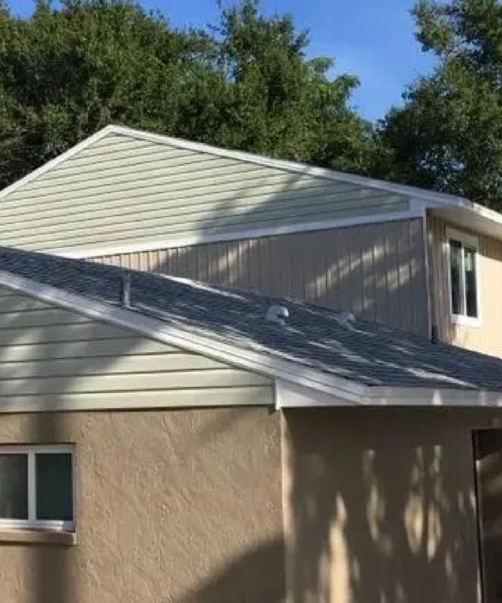 A house with a metal roof and a white wall.