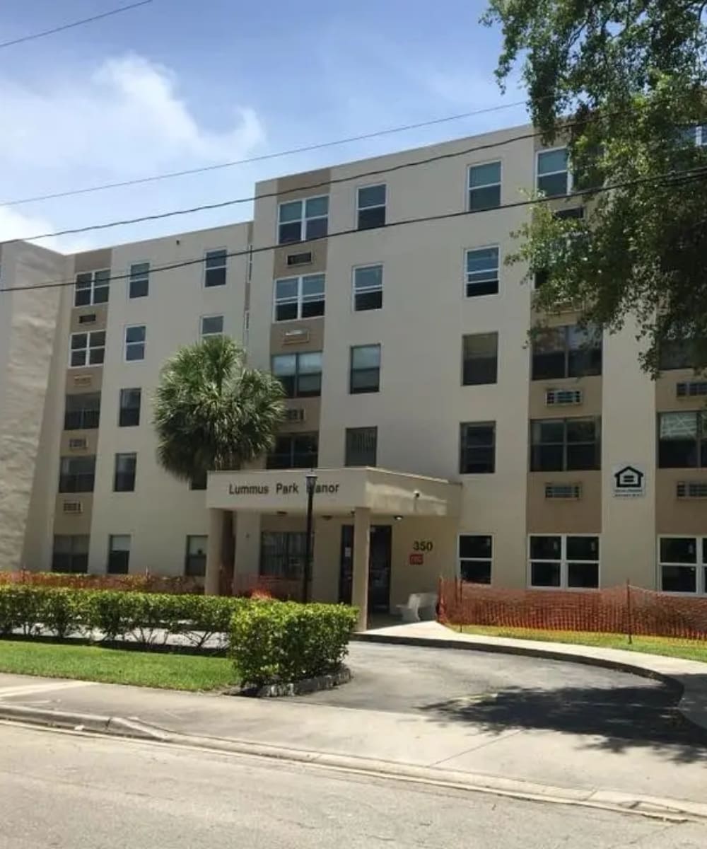 A large white building with trees in front of it.