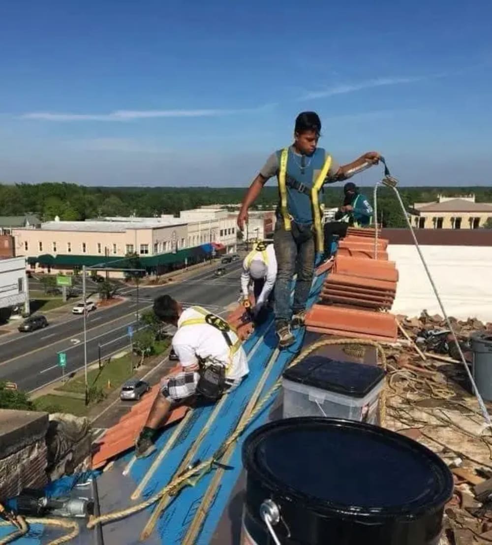 A group of men working on the roof of a building.